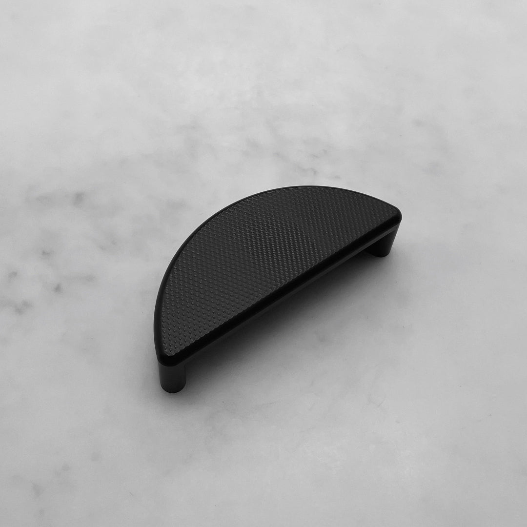 classic ceramic black cup pull handle for traditional shaker kitchen cabinetry with sleek knurl detail on front face in kent