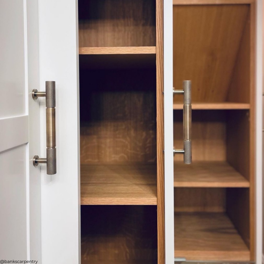 antique bronze (brushed brass) knurled cabinetry pull handle on modern white and oak wardrobe in Essex. Gary Banks Carpentry