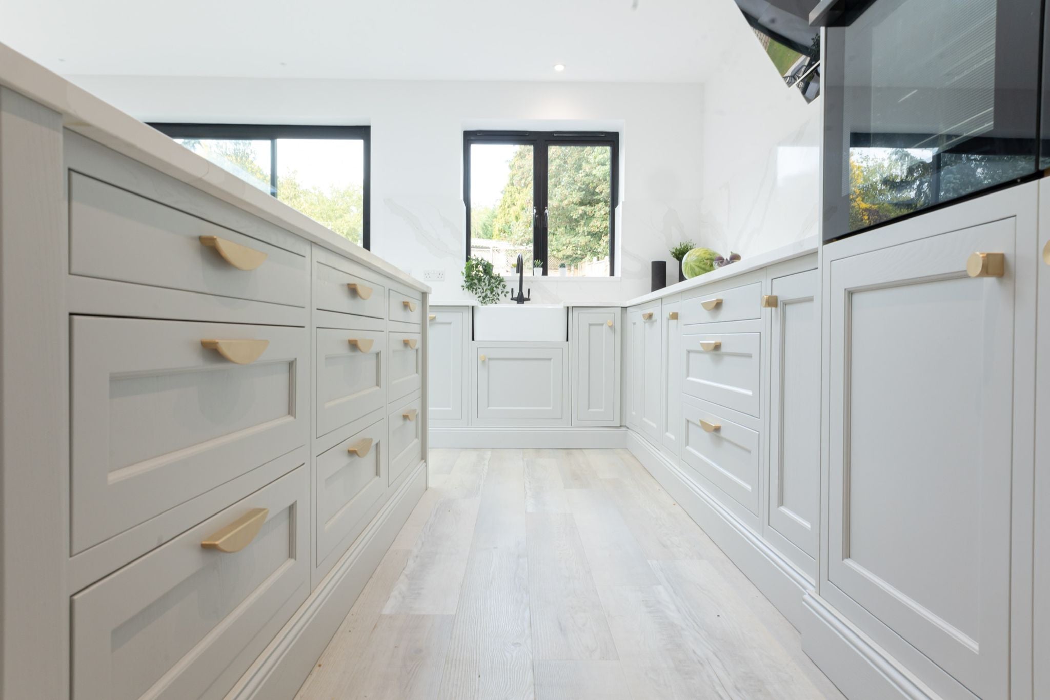 cranbrook crescent pull handle in satin brass. kitchen design cuffley by F&L kitchens. modern grey kitchen cabinetry hardware