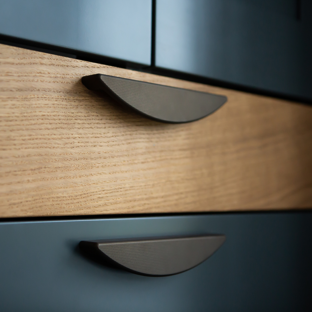 190mm cranbrook flat knurl crescent pulls on oak and dark blue bedroom chest of draws cabinetry. pete hill design wokingham