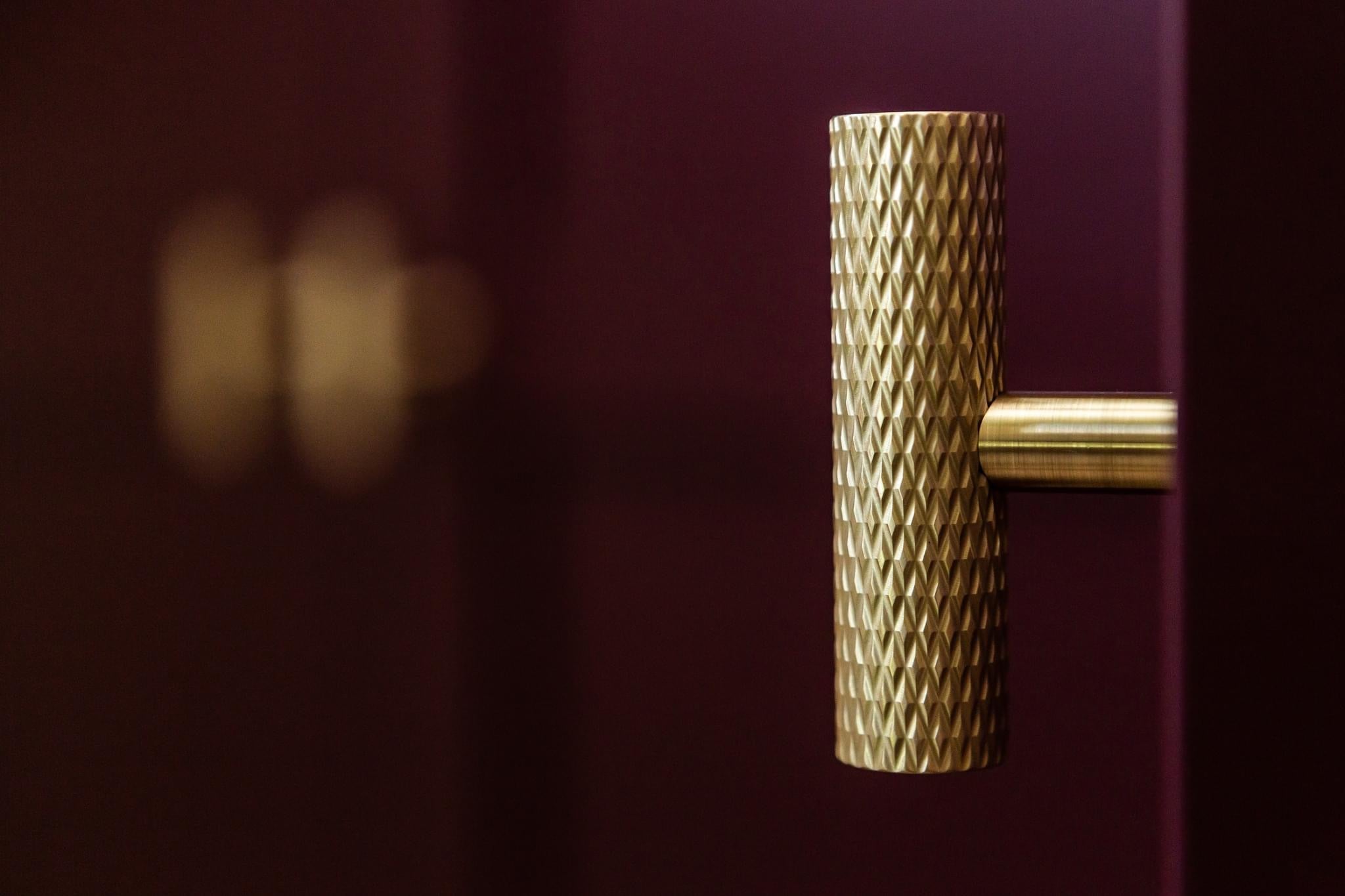 pete hill designs, wokingham, london. round t-bar with knurling in satin brass on red wardrobe cabinetry 