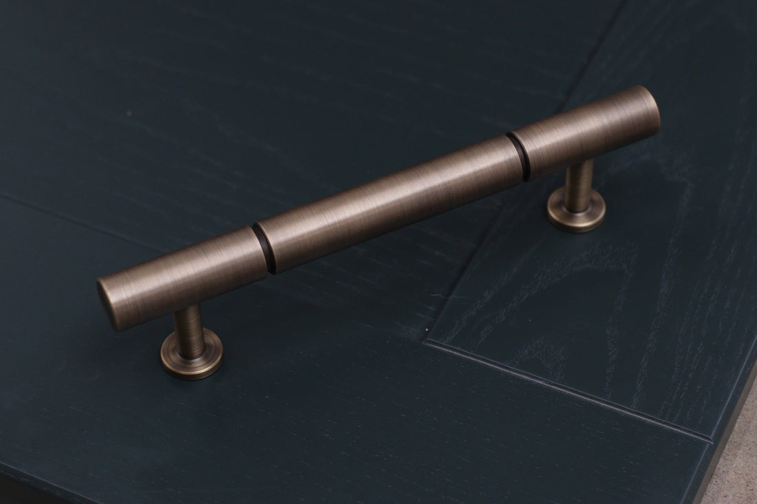 plain antique brushed brass bronze rounded pull handle with indent groove design. perfect minimal handle for kitchens 