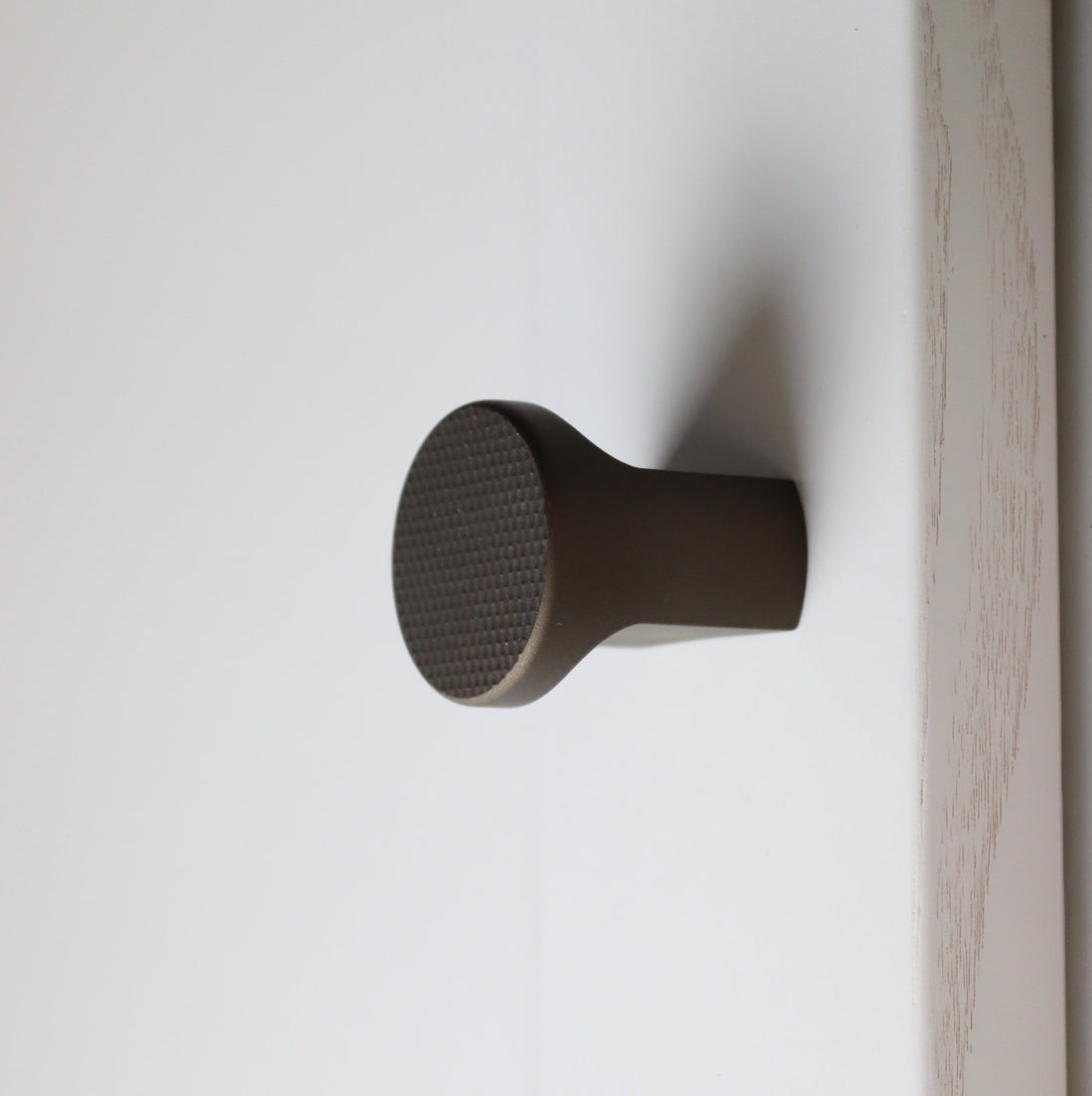 boscastle double finger pull knob for bedroom and bathroom cabinetry. flat knurl knob in midnight bronze 