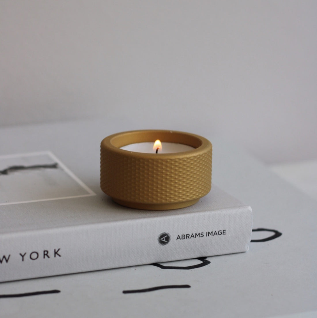 ceramic gold tea light candle holder for Christmas gift or Christmas decoration. styled on New York cereal magazine. Scandinavian interior design styling. modern and contemporary. knurled decoration. brass home decor. candle holder gift. housewarming gift.  styled by adrestiasrevolt.co.uk